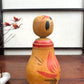 Poupée Japonaise Kokeshi nemariko de Sato Yoshihiro, avec un grand chrysanthème rouge peint à la main, vue profil droit