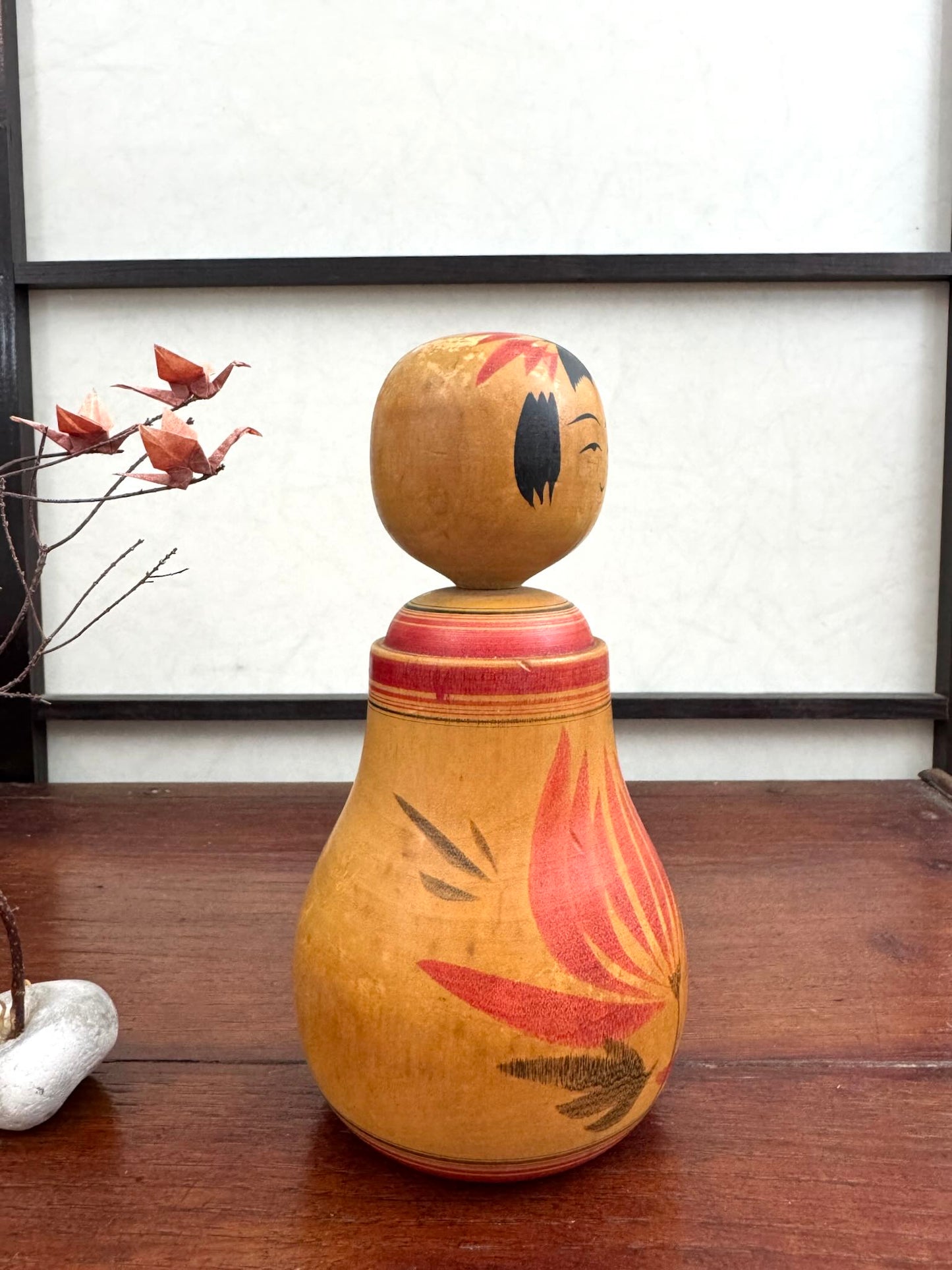 Poupée Japonaise Kokeshi nemariko de Sato Yoshihiro, avec un grand chrysanthème rouge peint à la main, vue profil droit