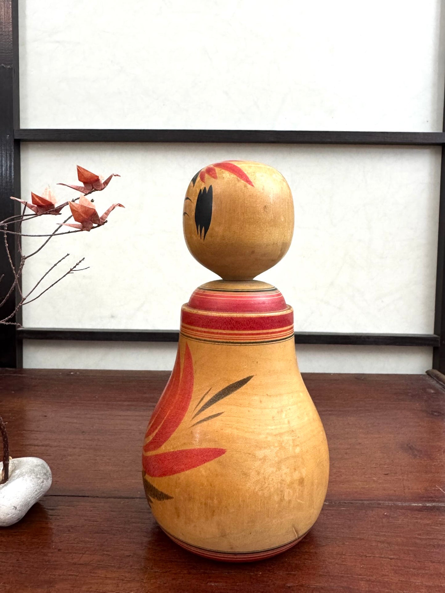 Poupée Japonaise Kokeshi nemariko de Sato Yoshihiro, avec un grand chrysanthème rouge peint à la main, profil gauche