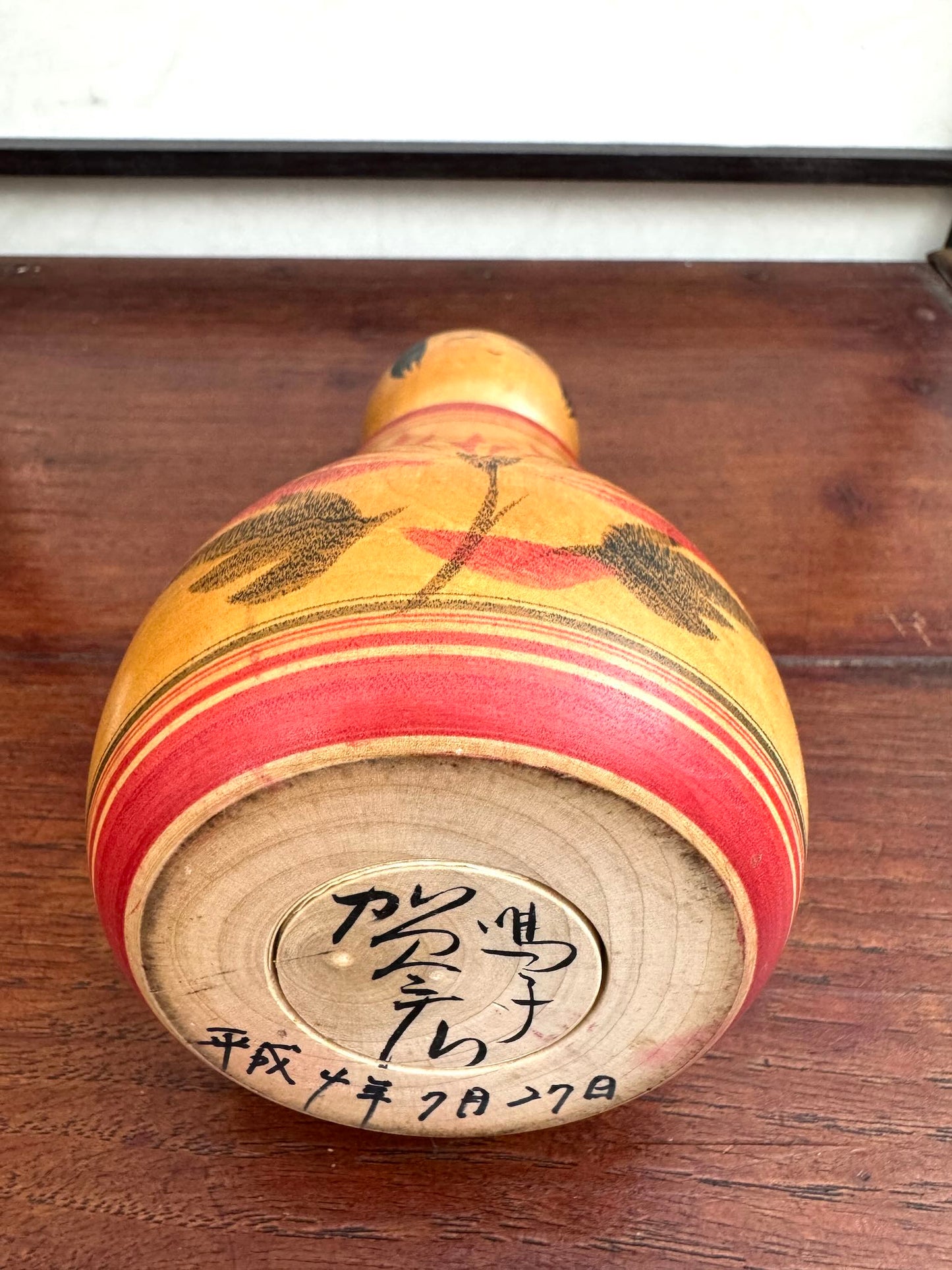 Poupée Japonaise Kokeshi nemariko de Sato Yoshihiro, avec un grand chrysanthème rouge peint à la main, signature dessous et date