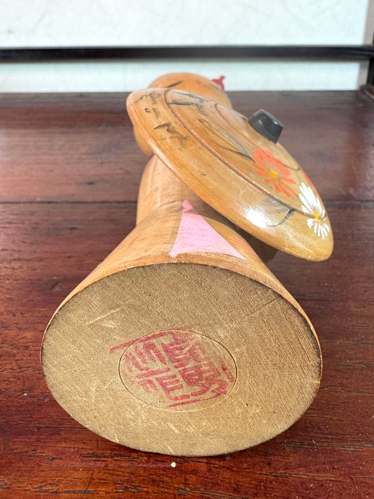 Kokeshi vintage Sadao Kishi représentant une femme à l’ombrelle fleurie, le sceau de l'artisan au dessous