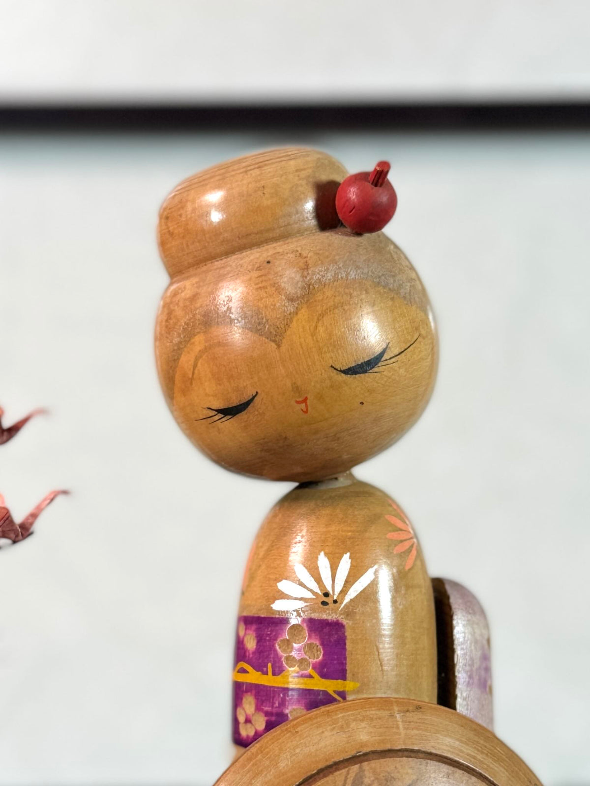 Kokeshi vintage Sadao Kishi représentant une femme à l’ombrelle fleurie, gros plan sur le visage aux longs cils