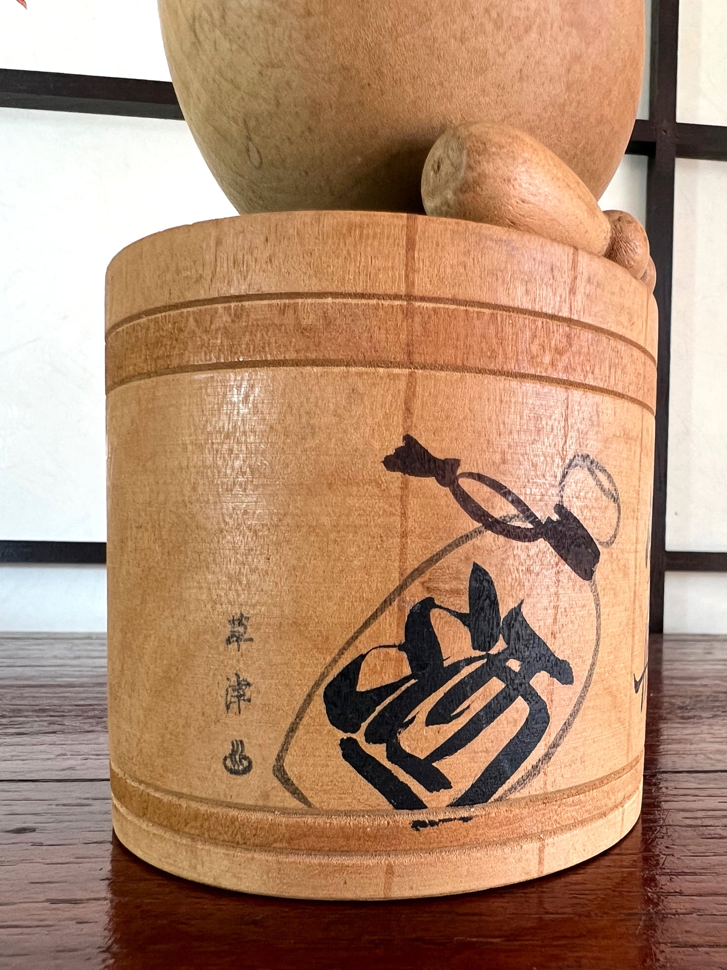 kokeshi poupée japonaise en bois dans son bain, bouteille de sake