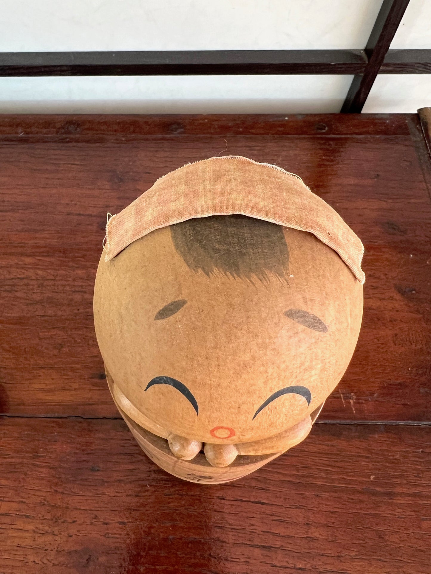 kokeshi poupée japonaise en bois dans son bain, serviette sur sa tête