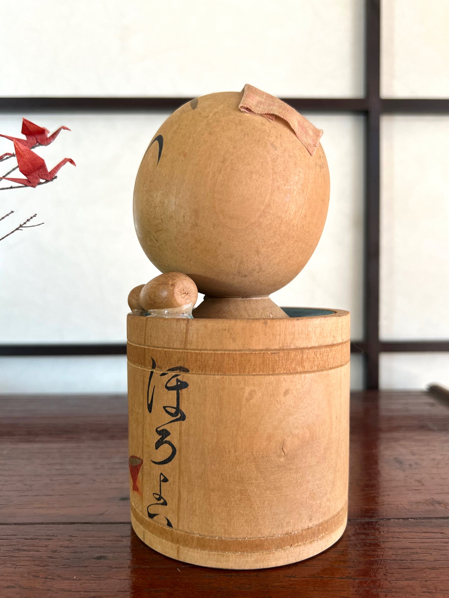 kokeshi poupée japonaise en bois dans son bain, profil gauche
