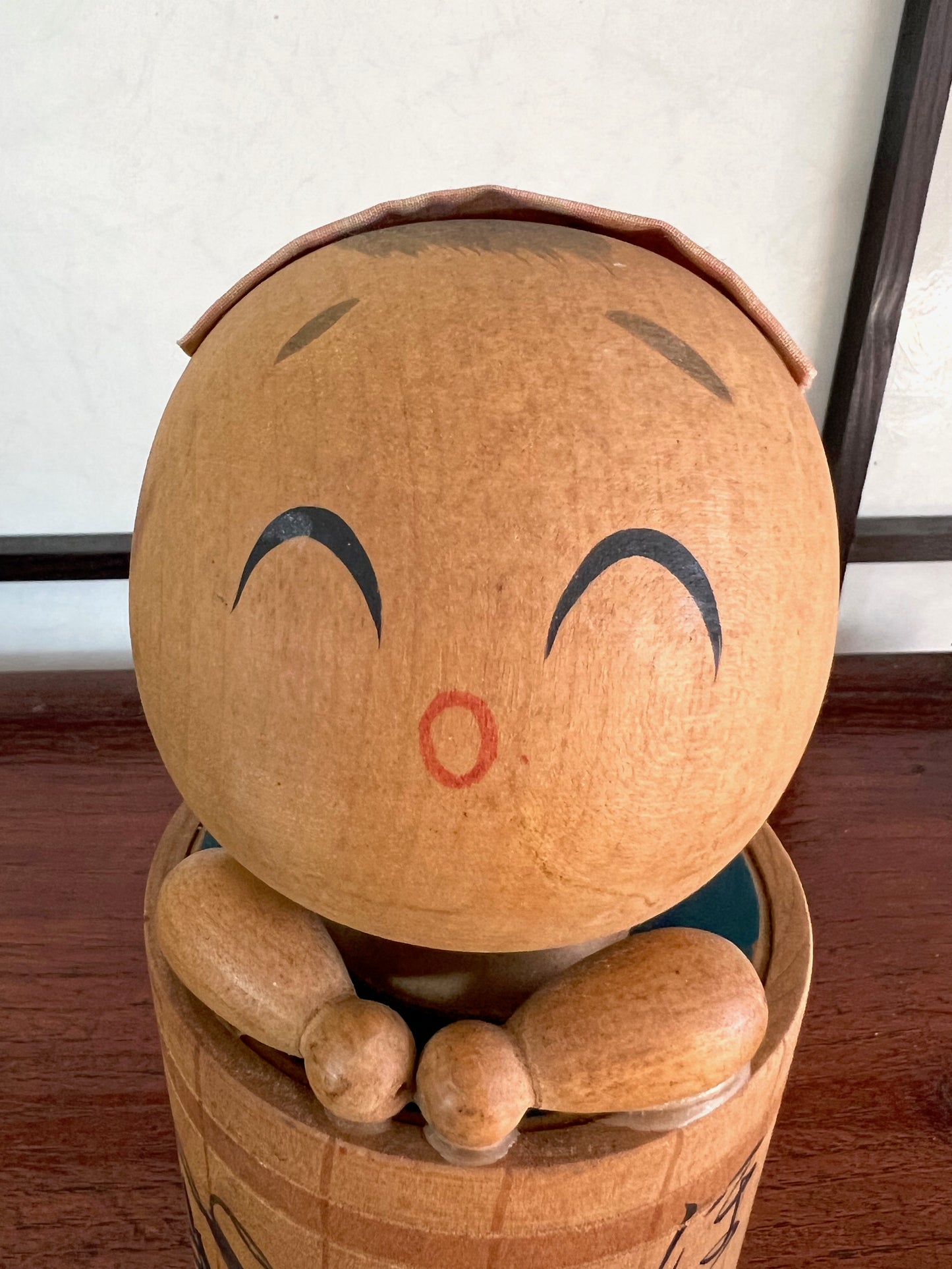 kokeshi poupée japonaise en bois dans son bain, son visage souriant