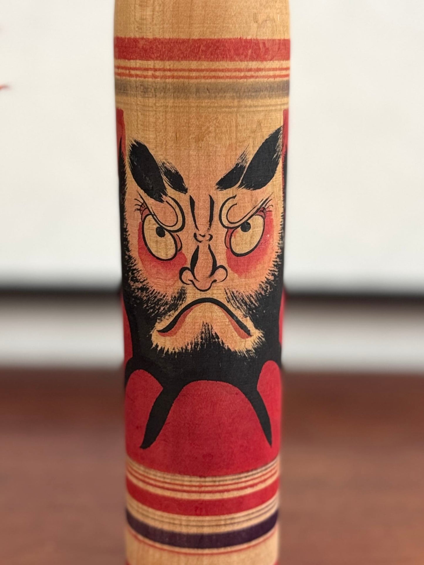 Kokeshi vintage Junichi Sasamori style Kohei avec visage de Daruma rouge et noir, gros plan sur le visage du daruma