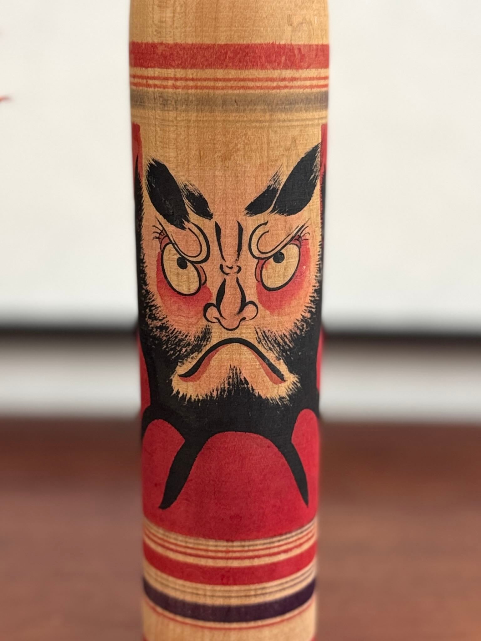 Kokeshi vintage Junichi Sasamori style Kohei avec visage de Daruma rouge et noir, gros plan sur le visage du daruma