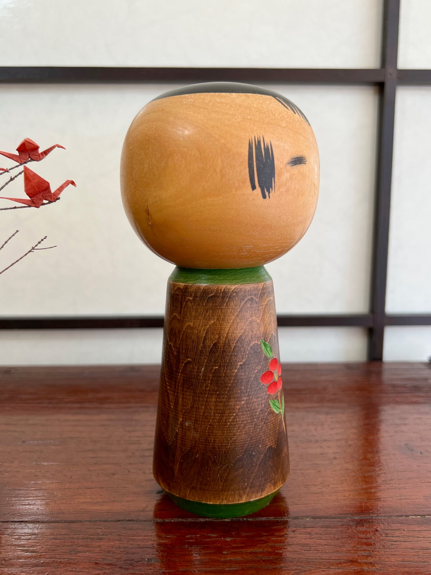kokeshi, poupée traditionnelle japonaise en bois avec une fleur de camélia rouge gravée, profil droit