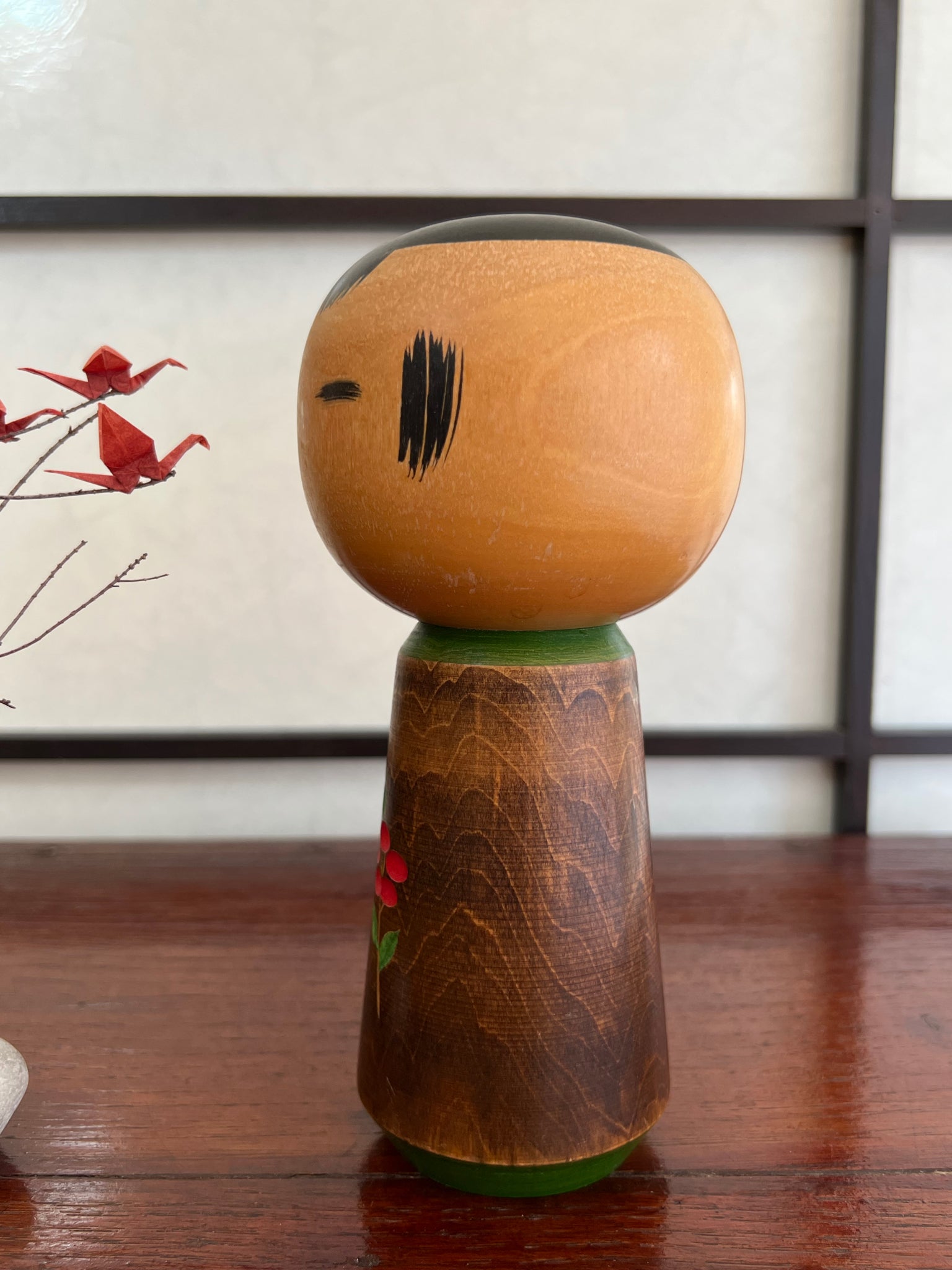 kokeshi, poupée traditionnelle japonaise en bois avec une fleur de camélia rouge gravée, profil gauche