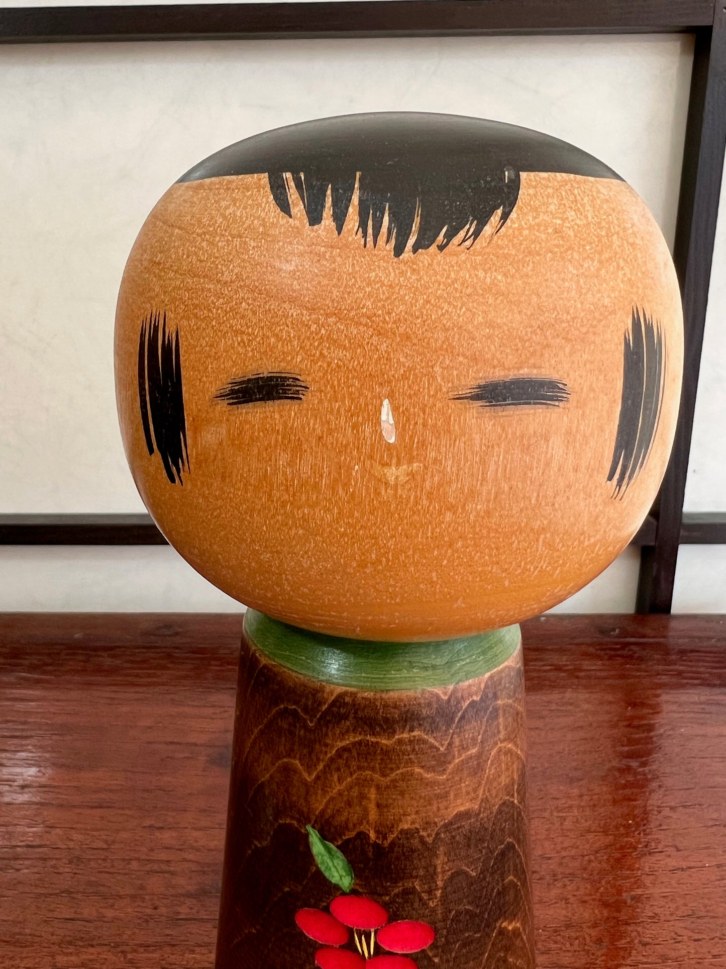 kokeshi, poupée traditionnelle japonaise en bois avec une fleur de camélia rouge gravée, la tête