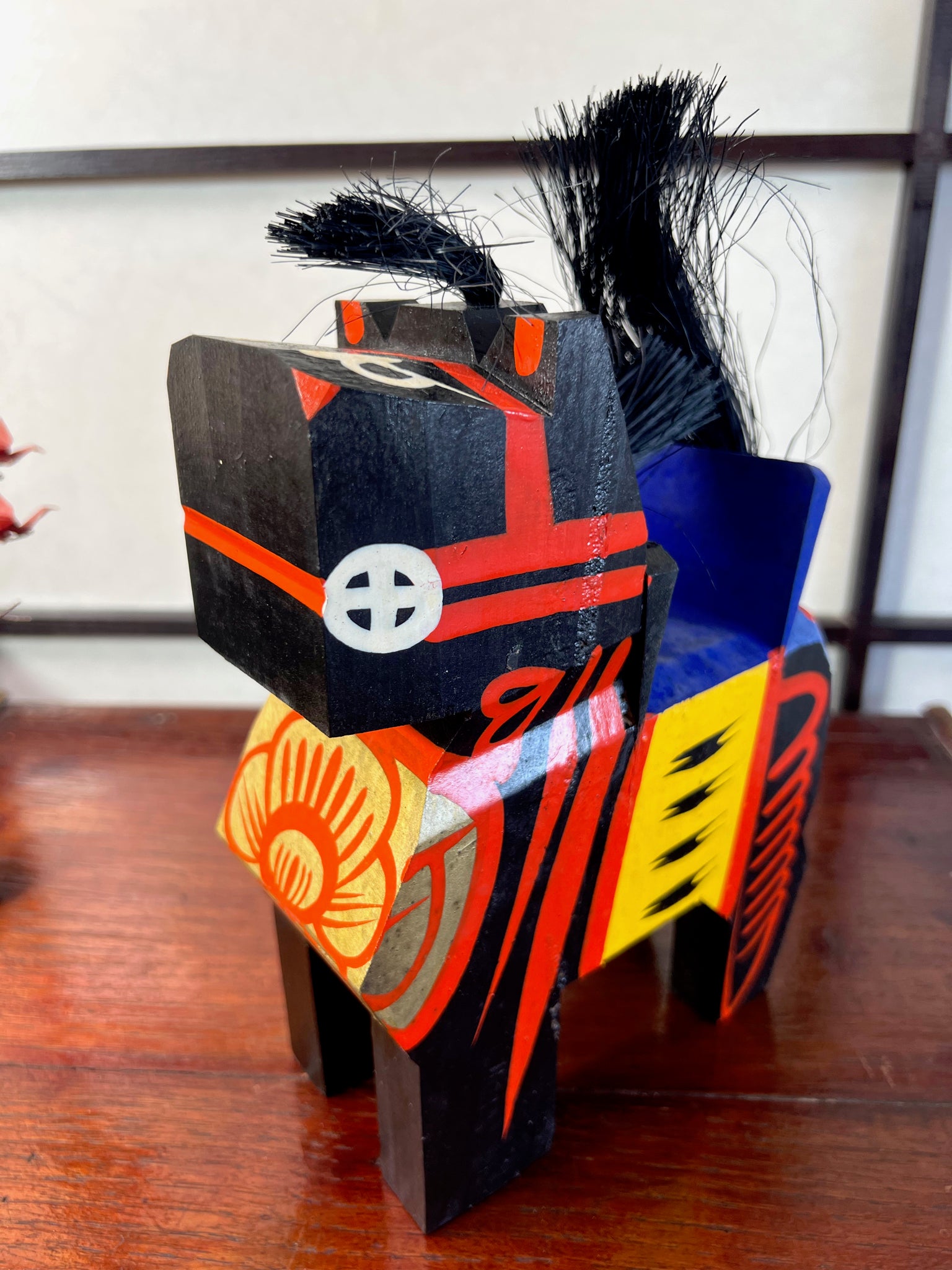 cheval japonais en bois peint noir et rouge, profil