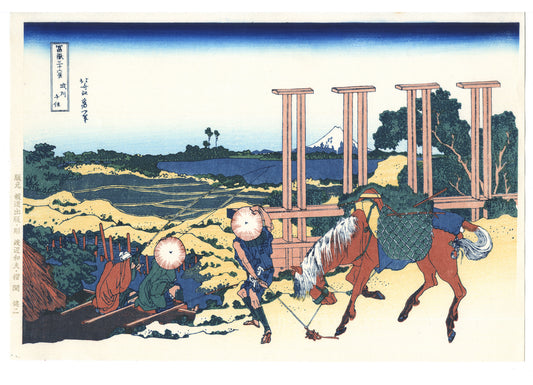 Estampe japonaise de Hokusai avec deux pêcheurs assis, un cheval chargé et le Mont Fuji en arrière-plan.