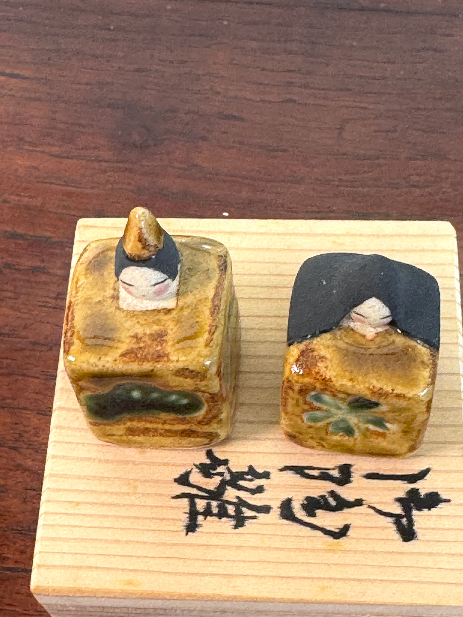 couple de poupées impériales japonaises cubiques en céramique émaillée sur boîte en bois, vu du dessus