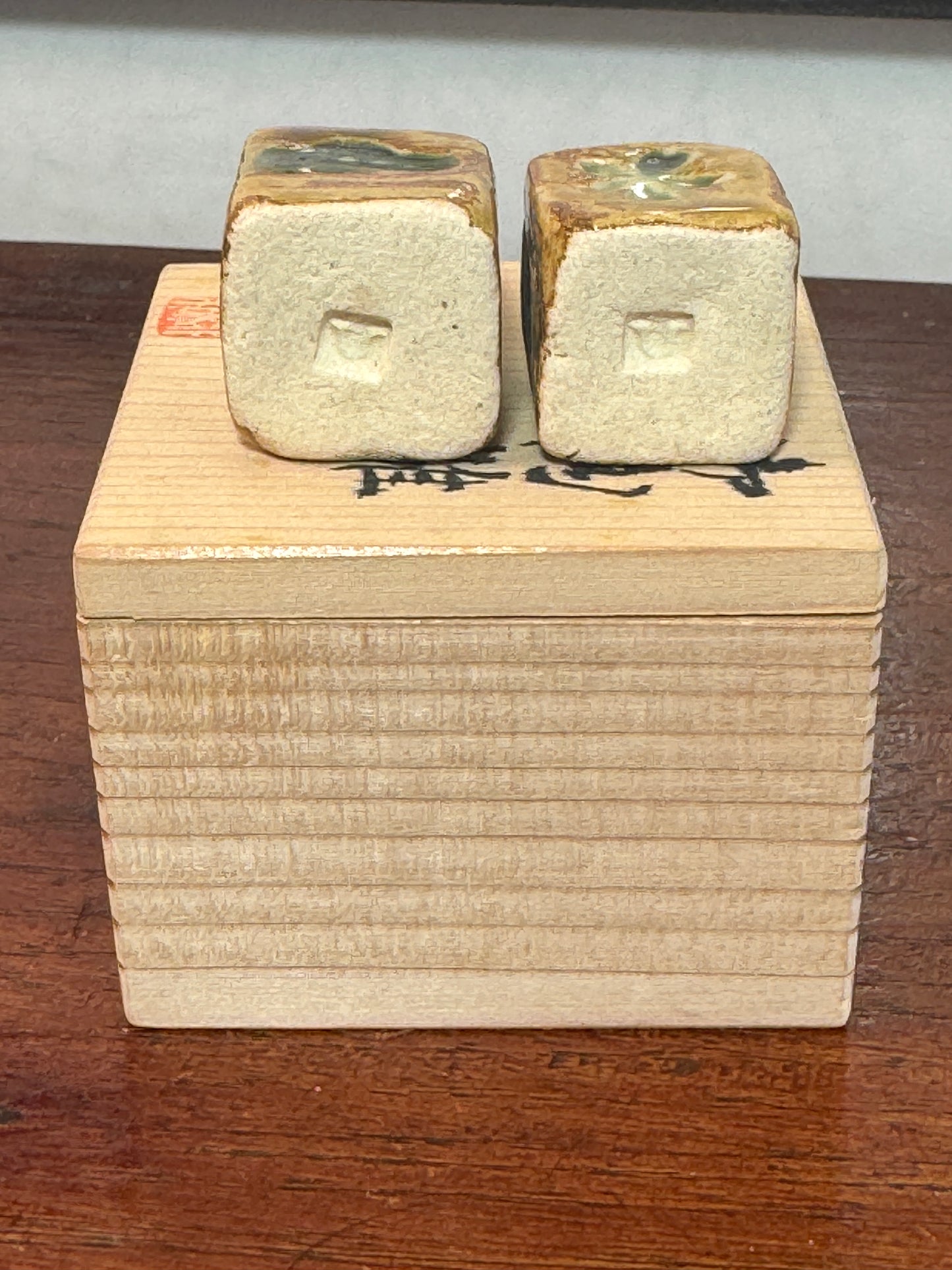 couple de poupées impériales japonaises cubiques en céramique émaillée sur boîte en bois, vu du dessous