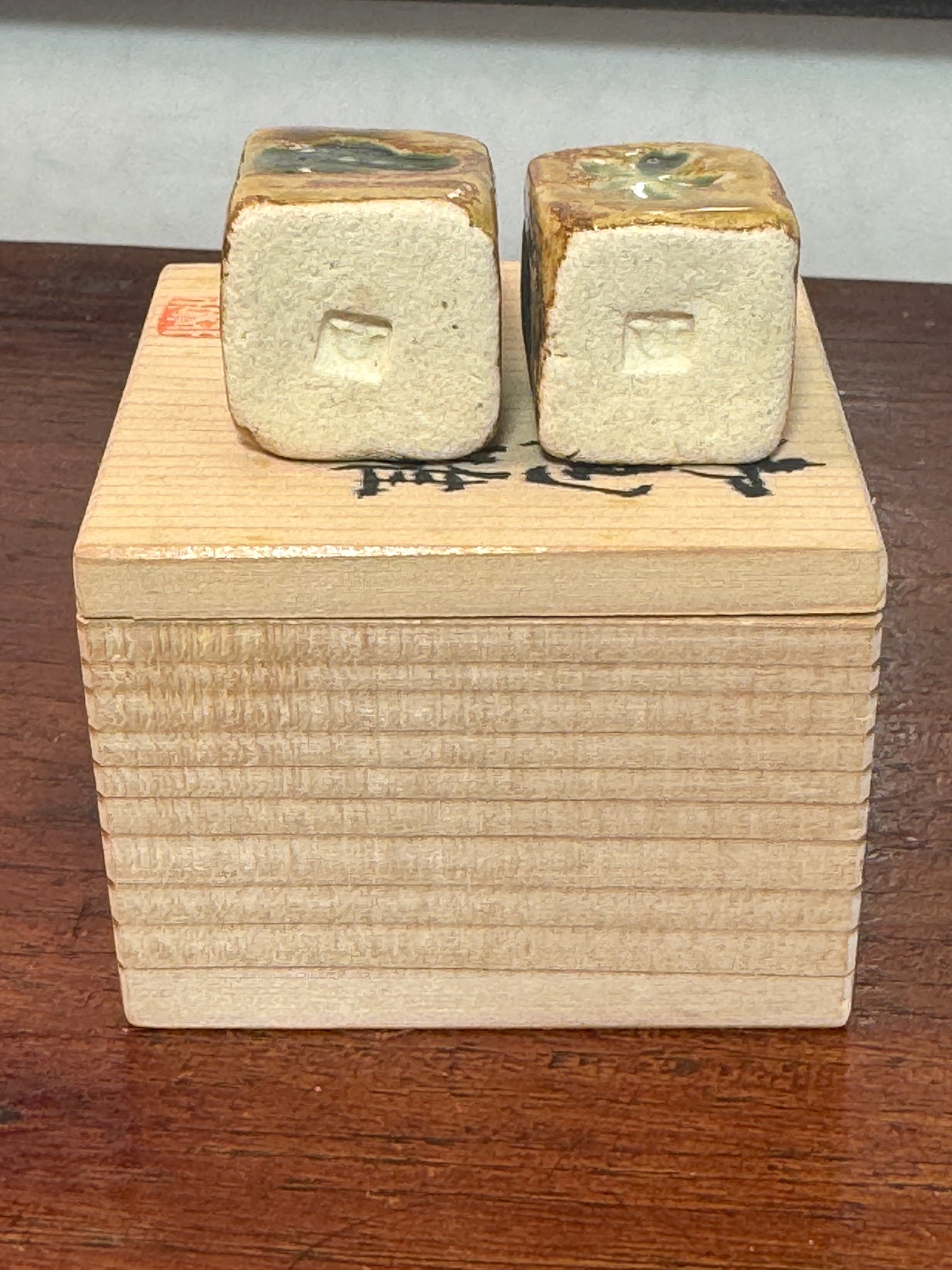 couple de poupées impériales japonaises cubiques en céramique émaillée sur boîte en bois, vu du dessous