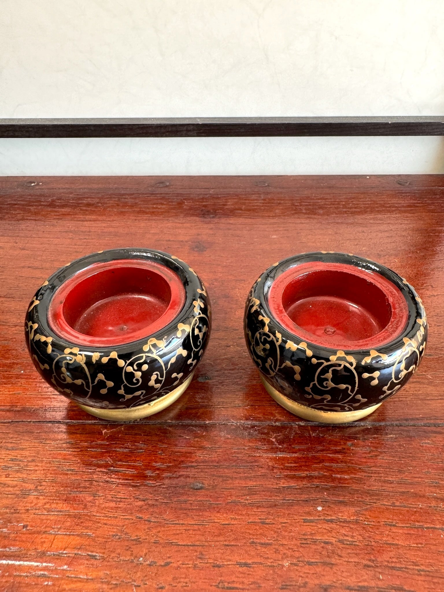 deux mini brasero japonais en laque noire motif fleurs pivoine dorées, vu de dessus fond rouge