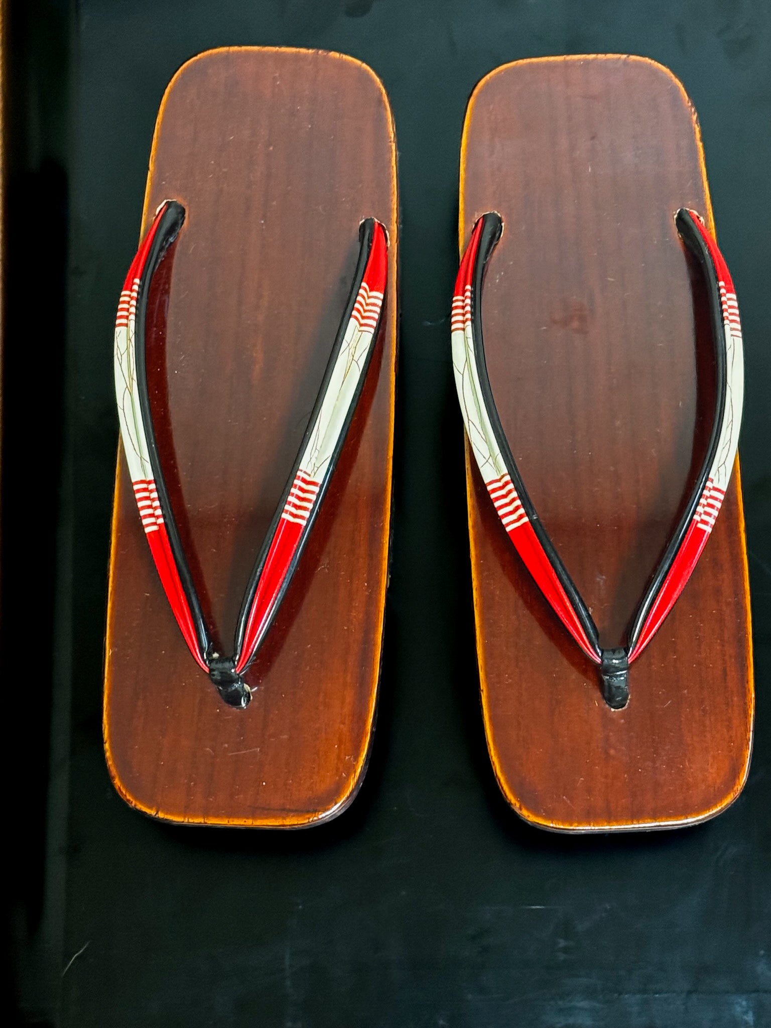 Paire de sandales geta japonaises en bois laqué brun avec lanières rouges et blanches