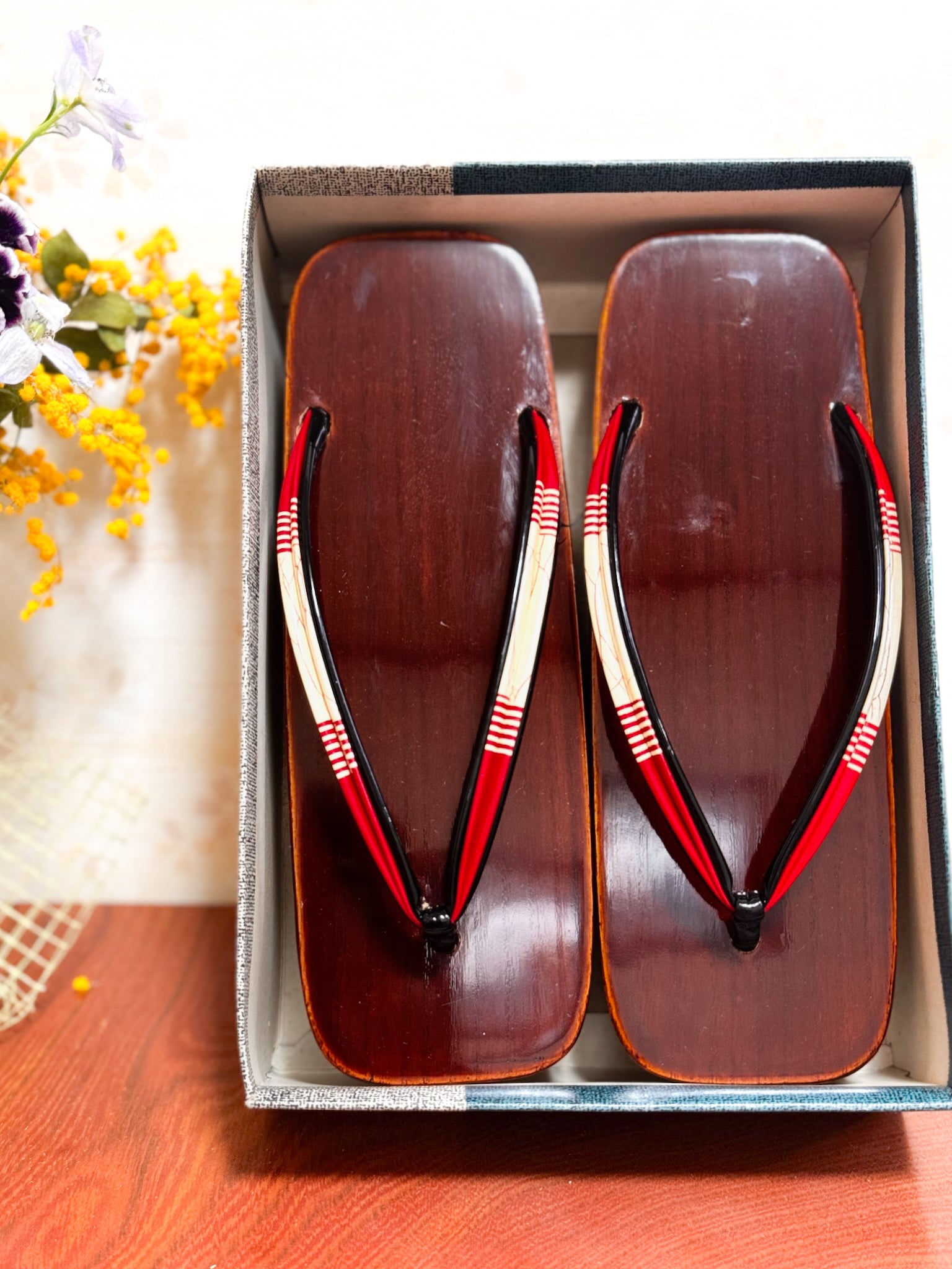 Paire de sandales geta japonaises en bois laqué brun avec lanières rouges et blanches, avec boite