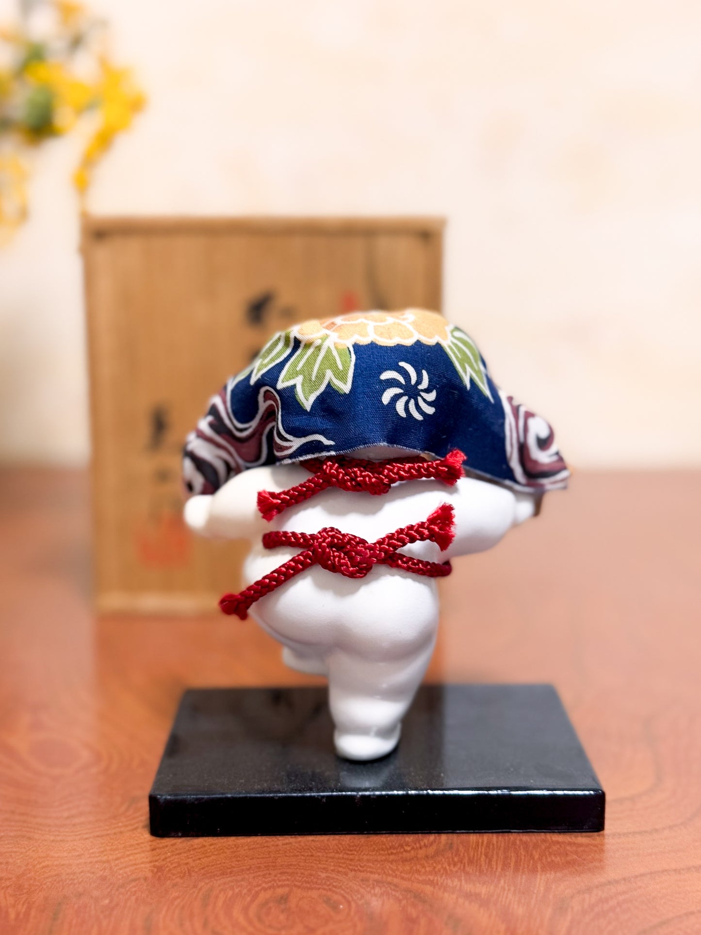 Figurine japonaise Gosho Ningyō représentant un enfant dansant avec une tête de lion Shishimai, sur socle laqué, avec boîte en bois calligraphiée, vu de dos
