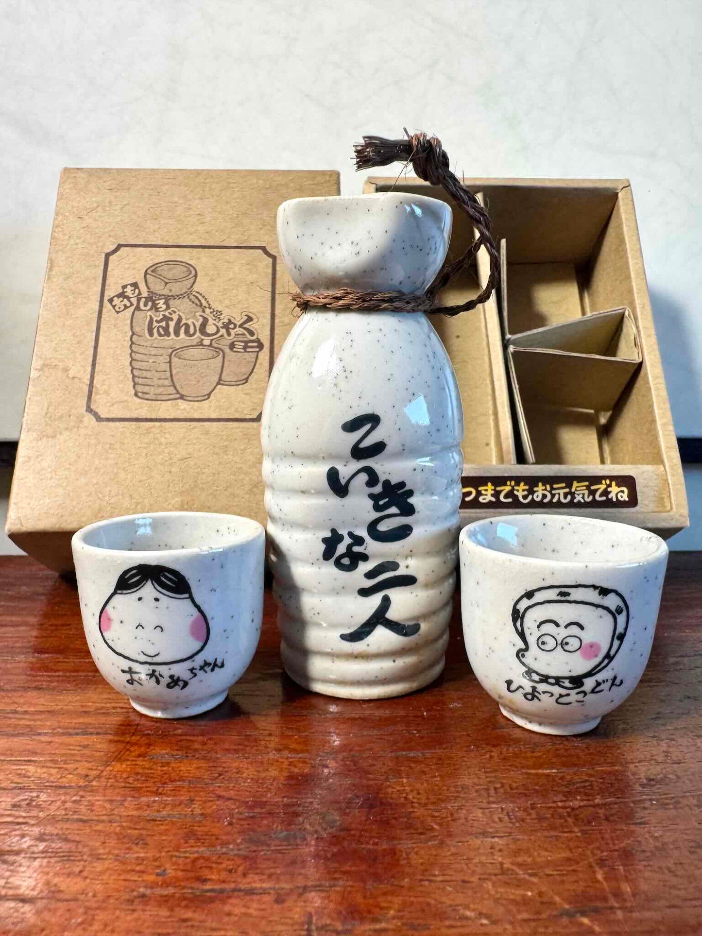 service saké japonais coffret okame hyottoko céramique, pichet et deux tasses vu de face