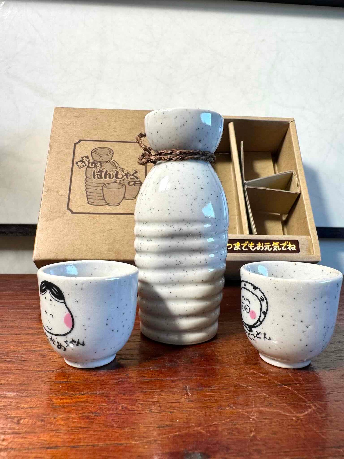 service saké japonais coffret okame hyottoko céramique, pichet et deux tasses vu de côté