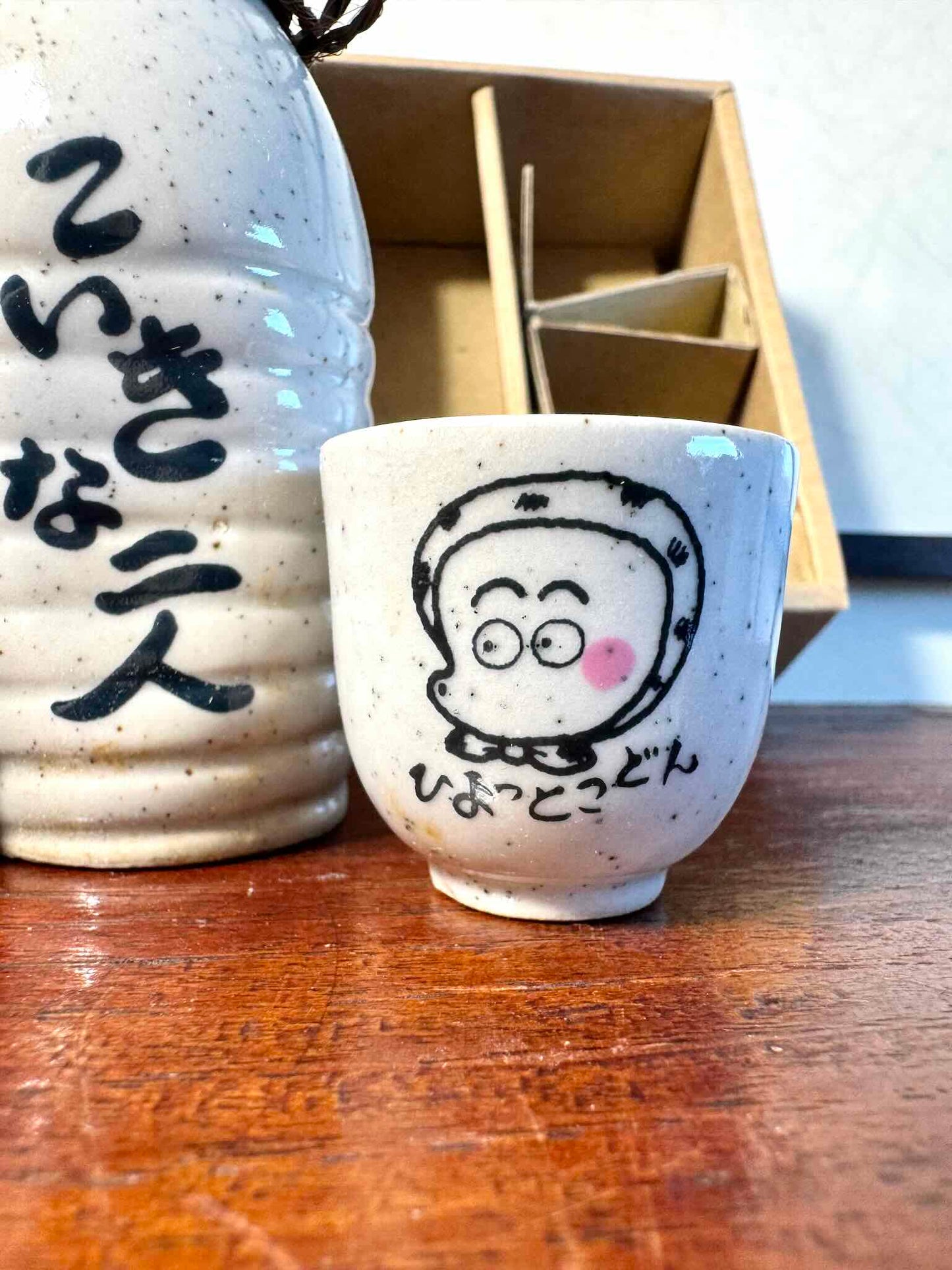 service saké japonais coffret okame hyottoko céramique, tasse hyottoko en gros plan
