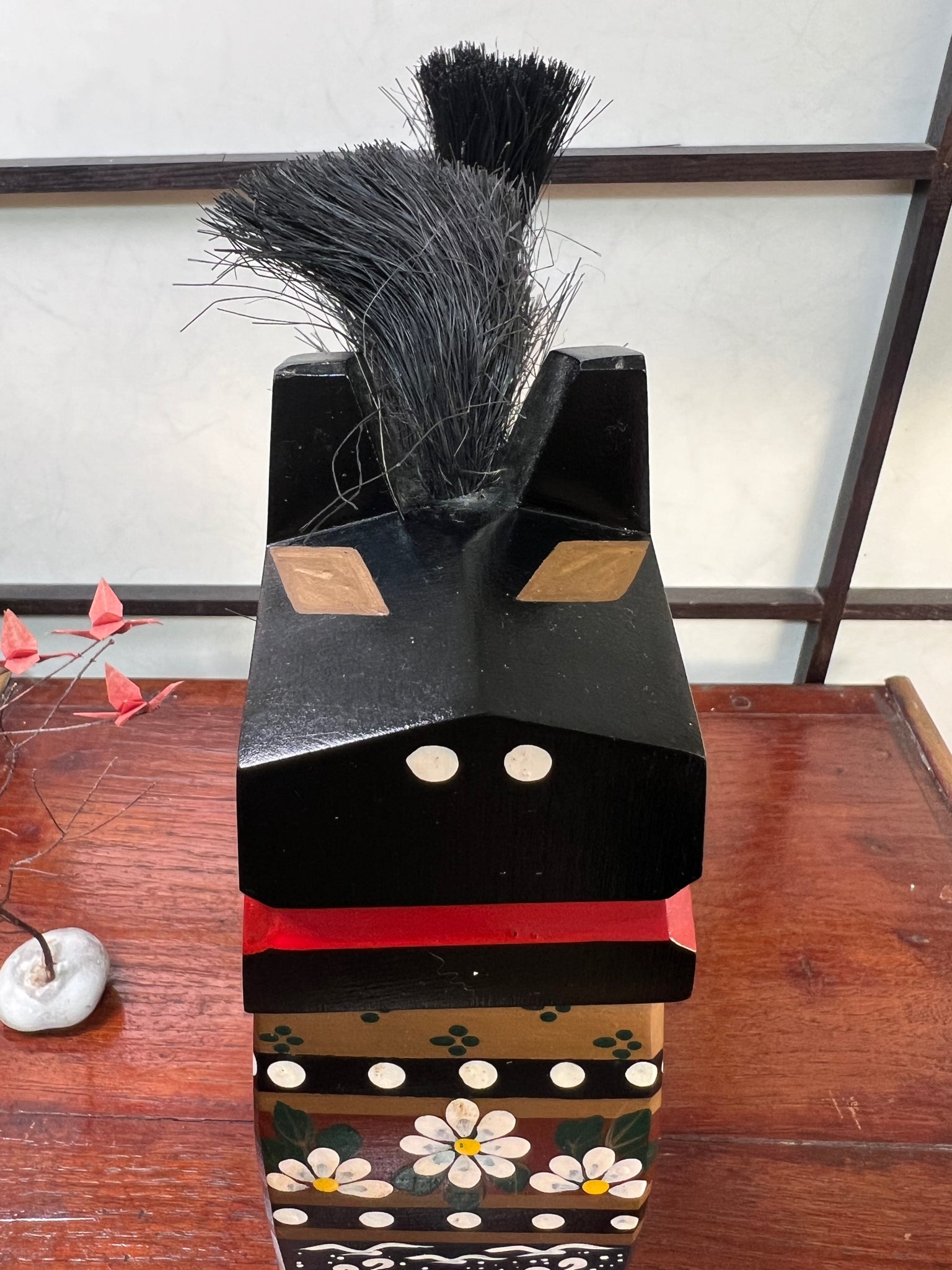 cheval traditionnel japonais en bois noir gros plan sur la tête, le museau blanc et bouche rouge