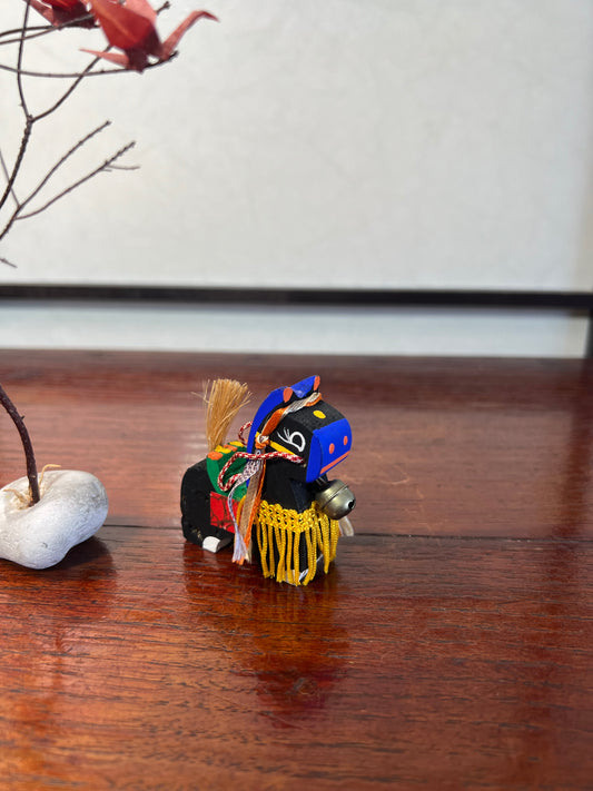 cheval traditionnel japonais en bois noir, museau et oreilles bleues, parures jaunes