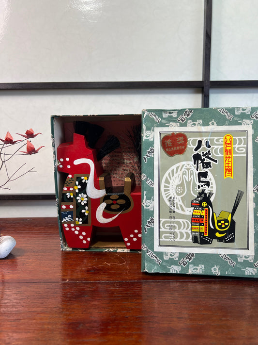 Cheval traditionnel en bois rouge dans sa boite écriture japonaise et dessin du cheval 