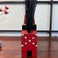 Cheval traditionnel en bois rouge de dos, queue relevée 