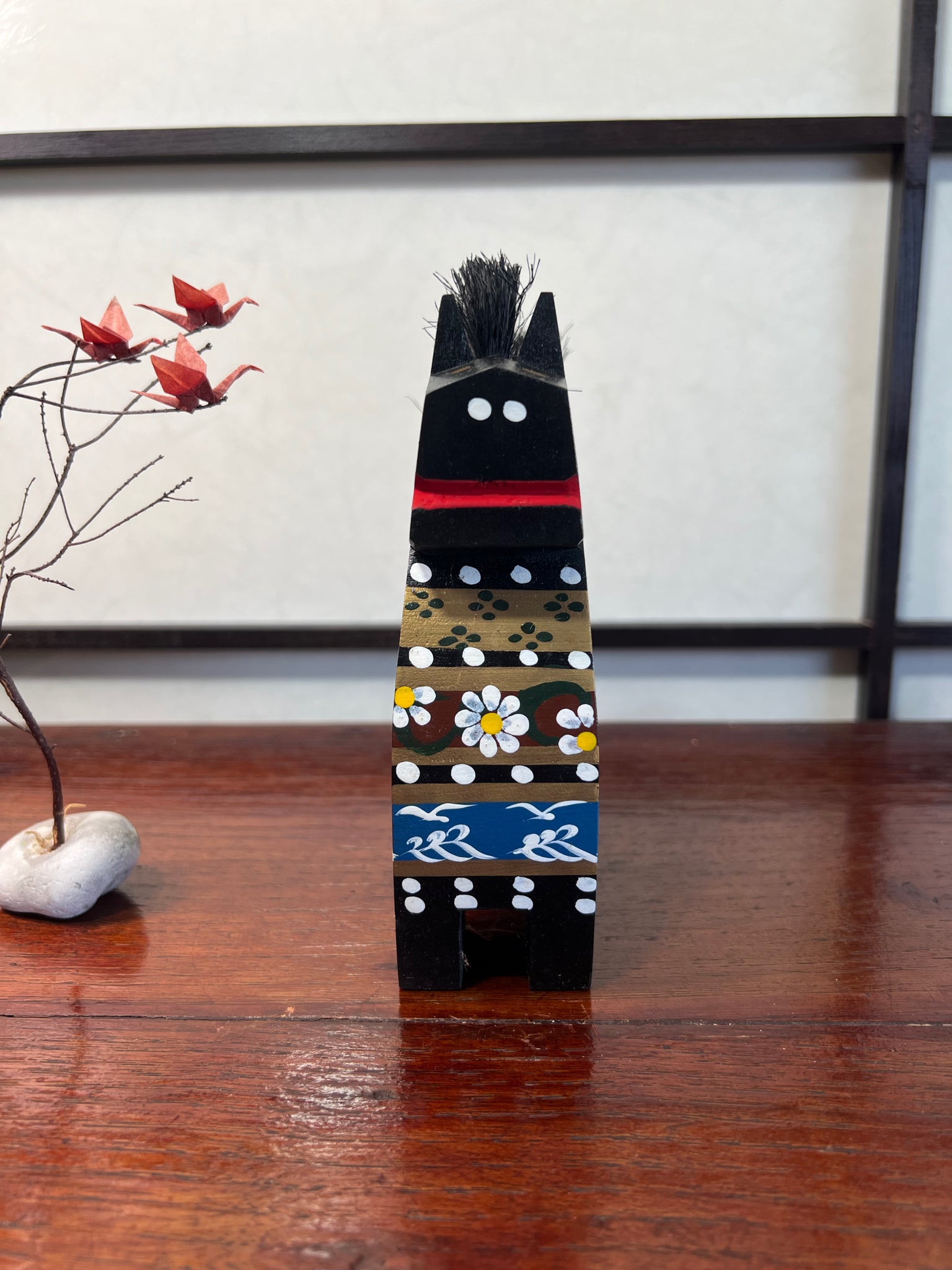 Cheval traditionnel japonais en bois noir de face, motifs sur son torse vagues oiseaux et fleurs