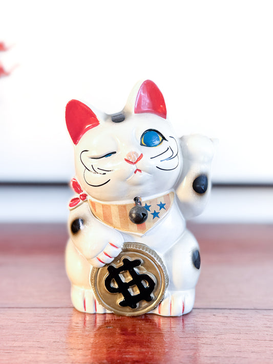 Maneki Neko blanc vintage avec clin d’œil, pièce dollar et motifs étoilés façon drapeau américain, face