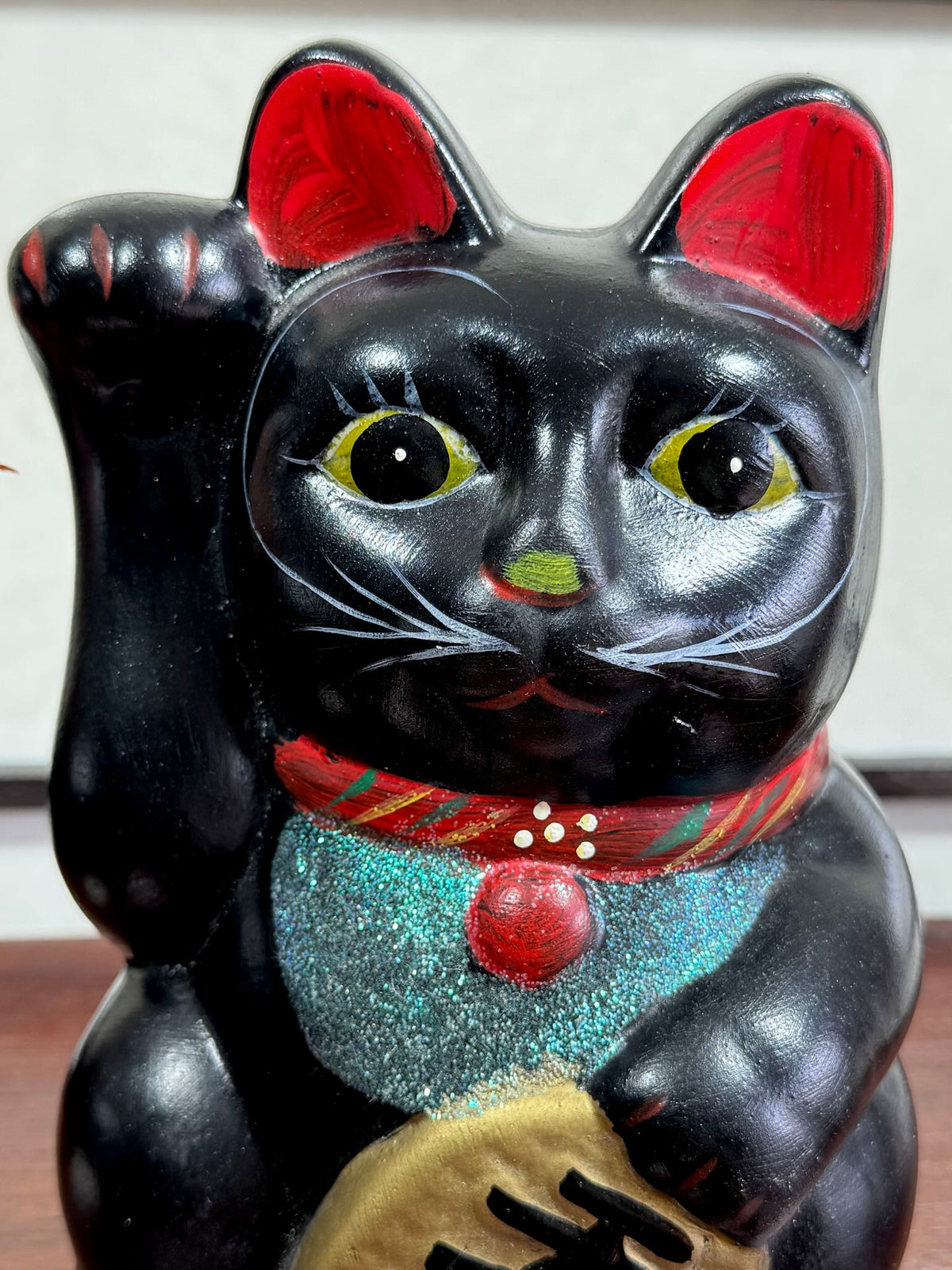 Chat japonais maneki neko noir de 21 cm, gros plan sur la tete du chat