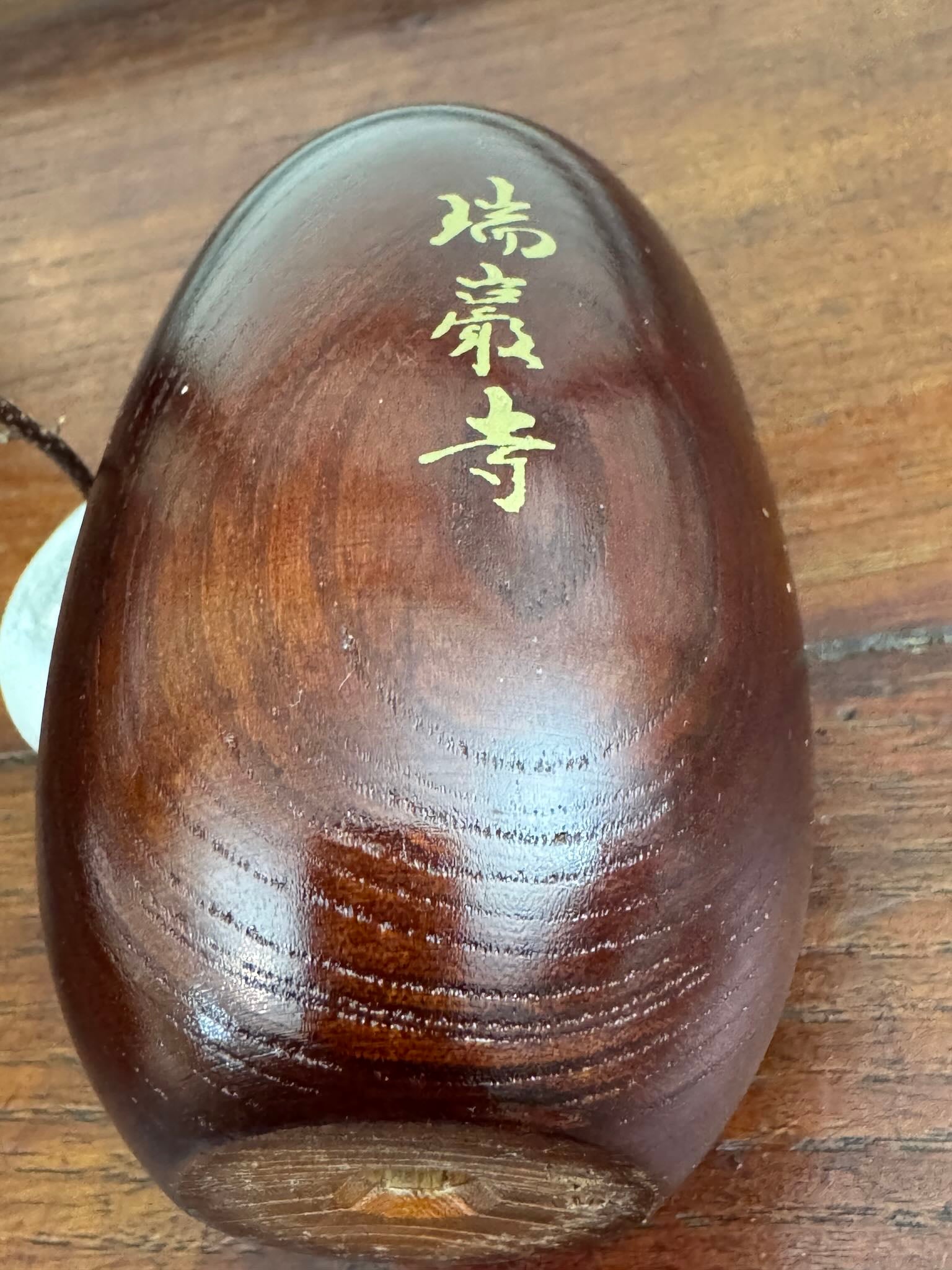 Daruma en bois venant du temple zuiganji a matsushima, caligraphie au dos