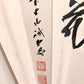 Éventail japonais en papier calligraphié avec les kanji fleur, lune, neige, gros plan sur calligraphie et sceaux rouges