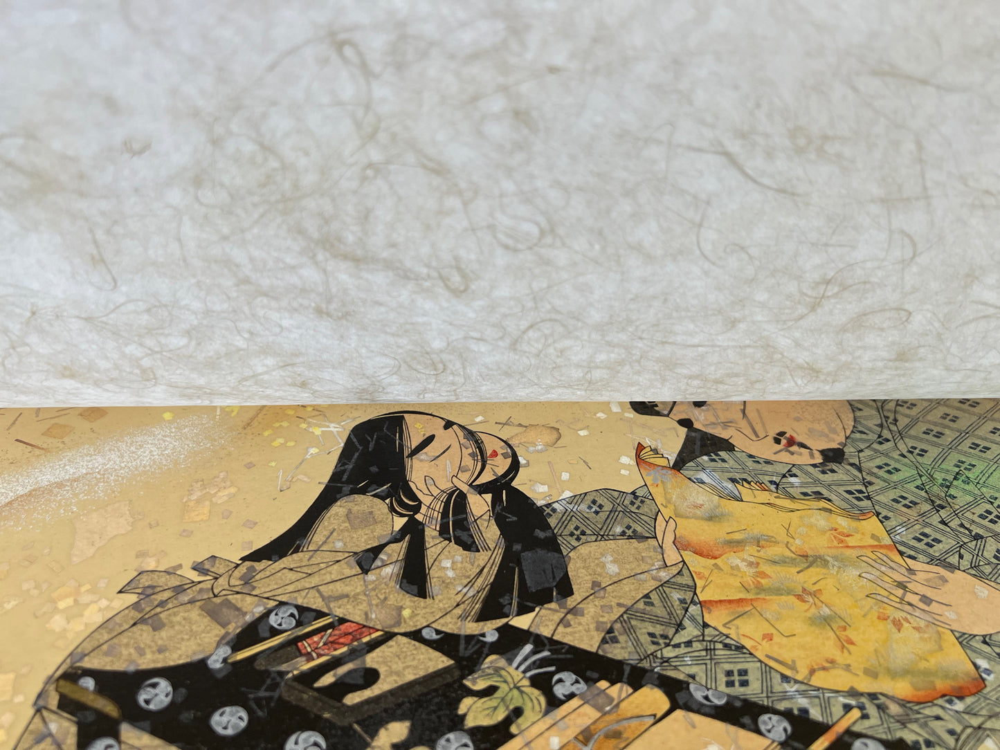 estampe japonaise en forme d'éventail parsemé de fragment d'or et d'argent, un homme lit un poème à une femme agenouillée, sous papier japonais de protection