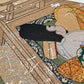 Estampe japonaise en forme d'éventail parsemée de fragments d'or et d'argent, gros plan homme de cour dormant tenant un éventail fermé, de dos, terrasse traditionnelle en bois.