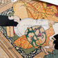 Estampe japonaise en forme d'éventail parsemée de fragments d'or et d'argent, gros plan deux hommes, homme de cour dormant, serviteur éventail, terrasse en bois.