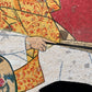 Estampe japonaise en forme d'éventail parsemée de fragments d'or et d'argent, gros plan main de l'homme de cour dormant tenant un éventail fermé.