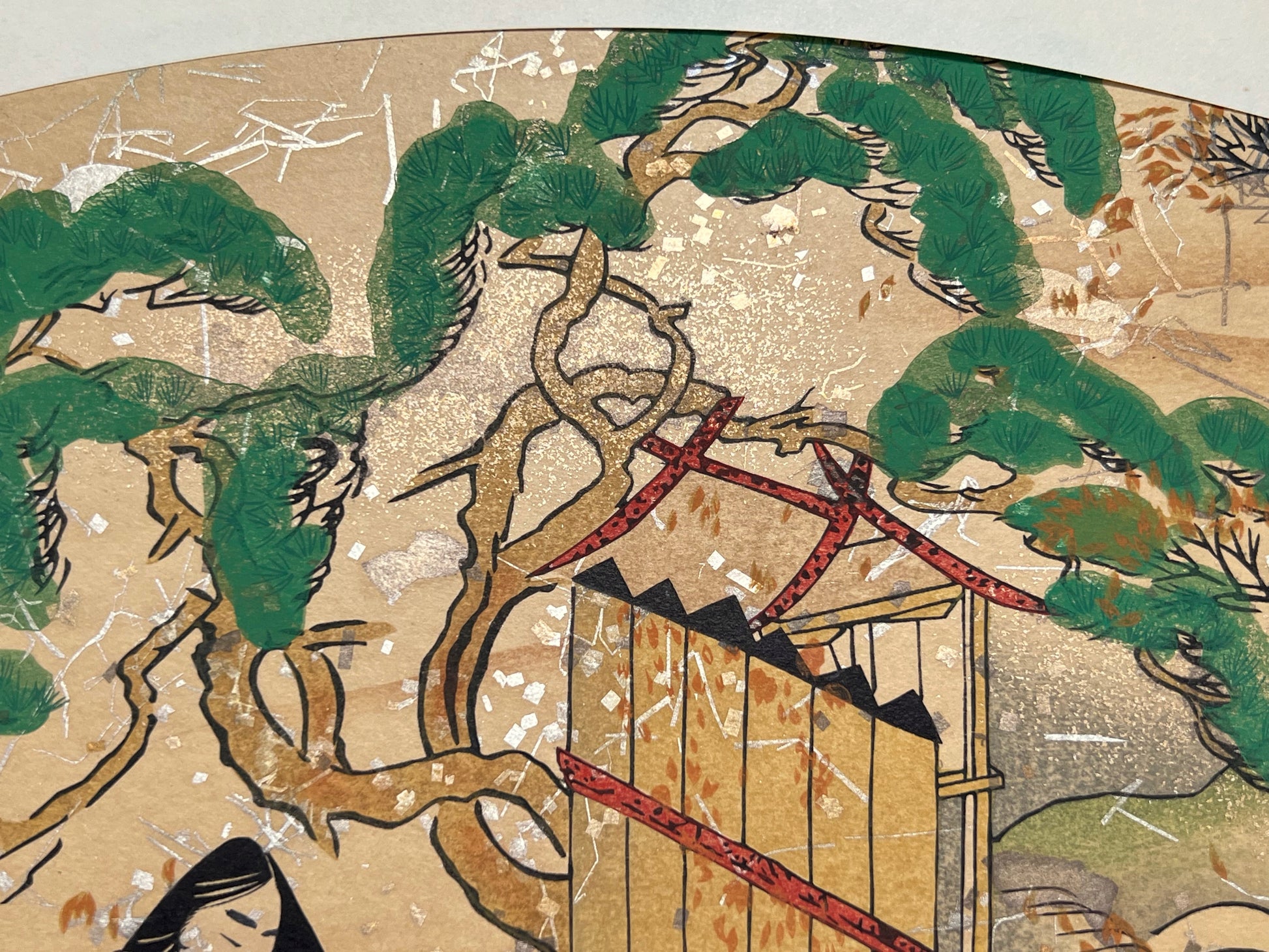 Estampe japonaise en forme d'éventail parsemée de fragments d'or et d'argent, deux femmes et un homme assis près d'un pin japonais, détail du pin et d'un sanctuaire.