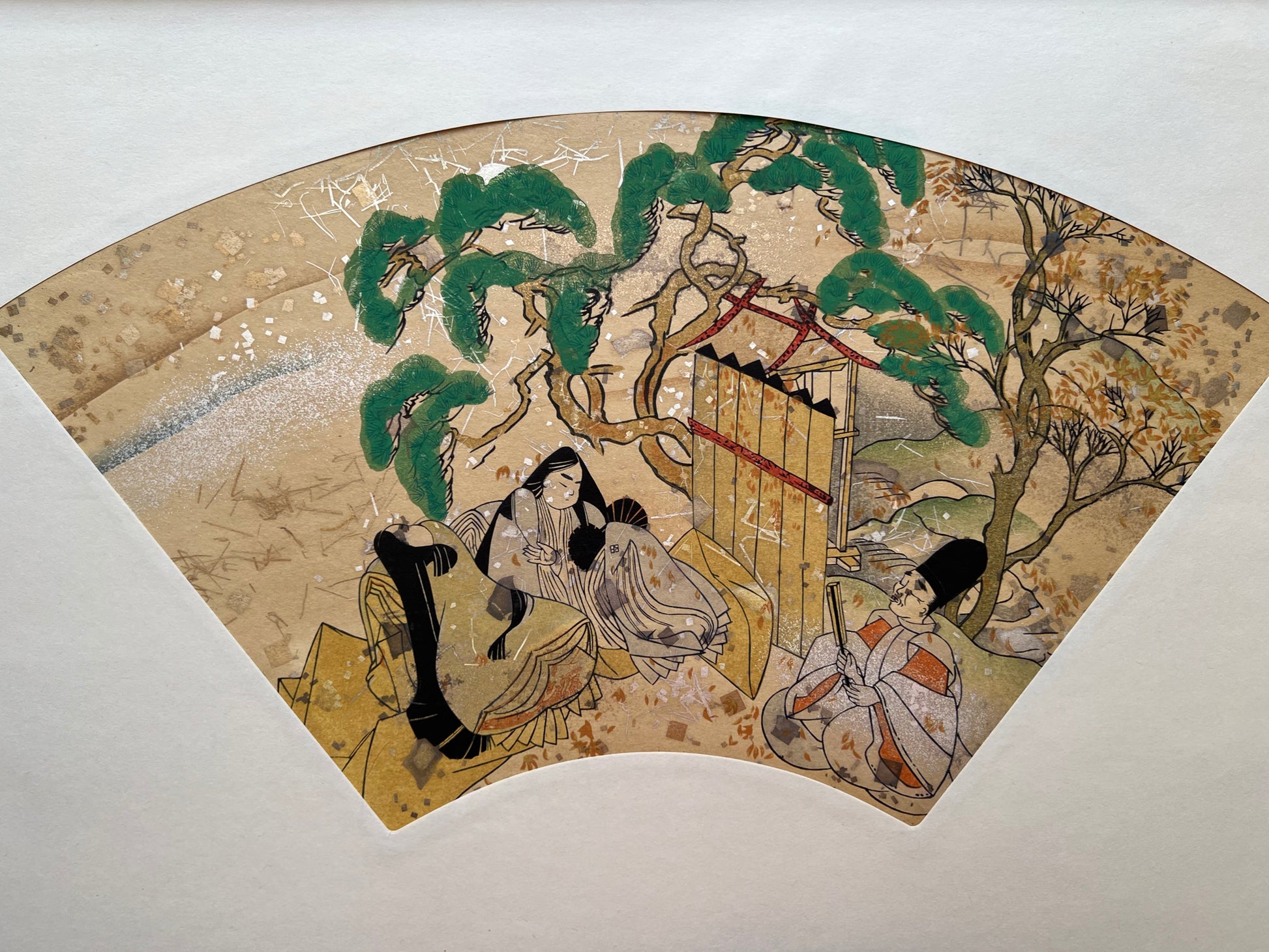 Estampe japonaise en forme d'éventail parsemée de fragments d'or et d'argent, deux femmes et un homme assis près d'un pin japonais, série sutra du lotus.