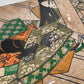 Estampe japonaise en forme d'éventail parsemée de fragments d'or et d'argent, gros plan sur la manche droite du kimono de la femme assoupie sur la terrasse.