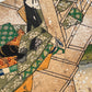 Estampe japonaise en forme d'éventail parsemée de fragments d'or et d'argent, femme tenant des bandelettes de tissu dans la main droite, assoupie sur une terrasse au-dessus d'une rivière, série sutra du lotus.