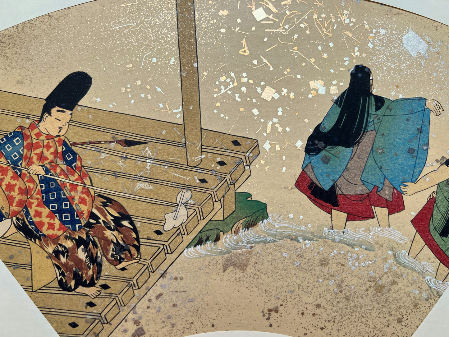 Estampe japonaise en forme d'éventail parsemée de fragments d'or et d'argent, gros plan sur la terrasse au-dessus de la rivière, homme qui passe la serpillère, femme se baignant.