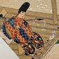 Estampe japonaise en forme d'éventail parsemée de fragments d'or et d'argent, gros plan sur l'homme passant la serpillère sur la terrasse à gauche de l'estampe.