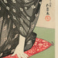 Estampe japonaise détail de l’estampe, la main et le coussin rouge sur lequel la femme est assise