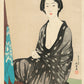 Estampe japonaise d’une femme assise en kimono noir transparent avec motifs blancs 