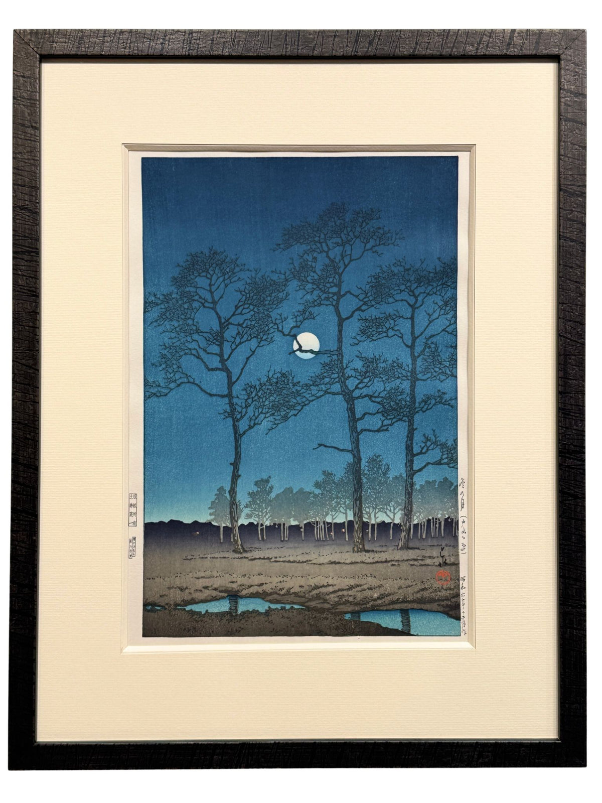 estampe japonaise encadrée de Hasui Kawase paysage nocturne lune d'hiver a Toyama arbre et ombre dans la nuit, avec bisau, passe-partout et cadre noir imitation bois brulé