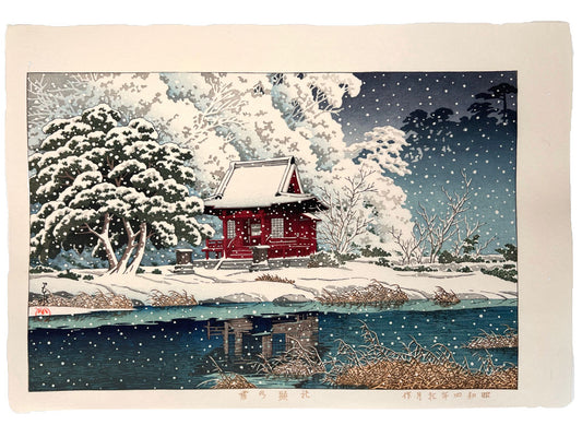 estampe japonaise de hasui kawase petit temple rouge sous la neige, au bord d'une rivière